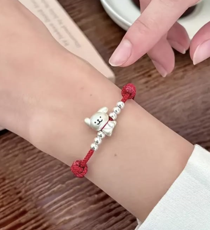 Pulsera tejida en rojo con dije plateado de perro